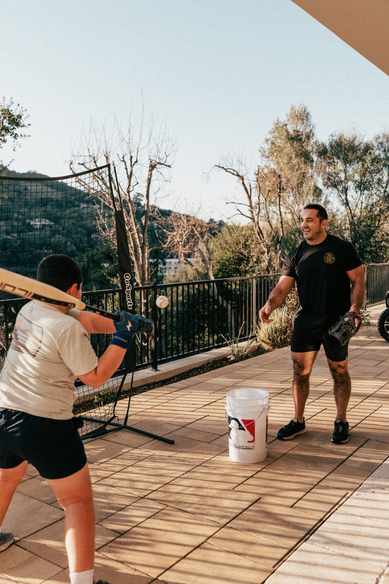 Jason Khalipa playing baseball with his son at home